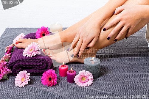 Image of Bare feet of a woman surrounded by flowers