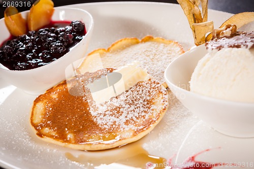 Image of tasty sweet pancakes with vanilla icecream and topping