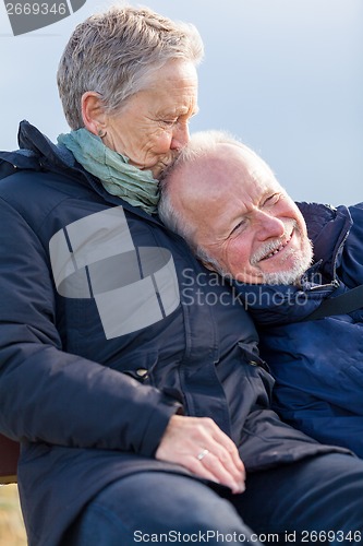 Image of happy senior couple relaxing together in the sunshine