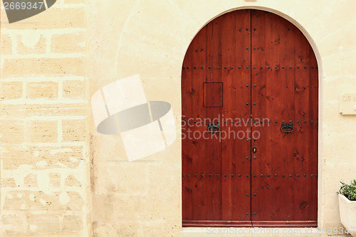 Image of Arched wooden door in a stone wall