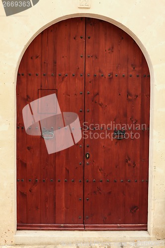 Image of Arched wooden door in a stone wall