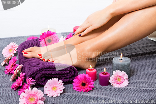 Image of Bare feet of a woman surrounded by flowers