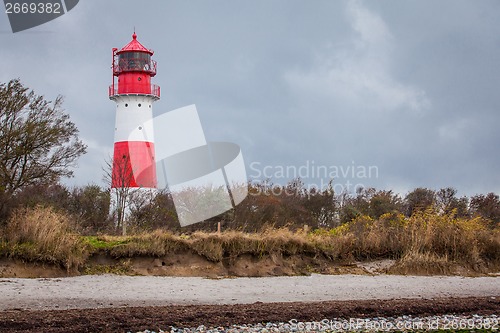 Image of landscape baltic sea dunes lighthouse in red and white 