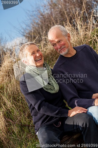 Image of happy senior couple relaxing together in the sunshine