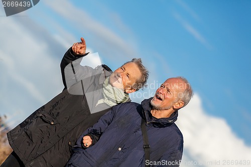 Image of happy elderly senior couple walking on beach