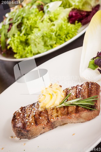 Image of Grilled beef steak topped with butter and rosemary