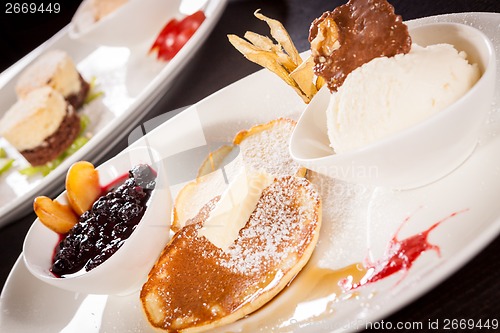 Image of tasty sweet pancakes with vanilla icecream and topping