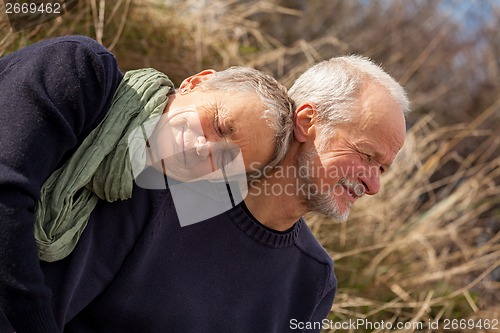 Image of happy senior couple relaxing together in the sunshine