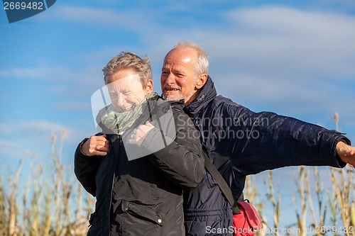 Image of Elderly couple embracing and celebrating the sun