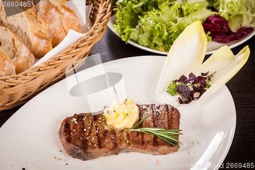 Image of Grilled beef steak topped with butter and rosemary