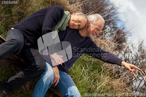 Image of happy senior couple relaxing together in the sunshine