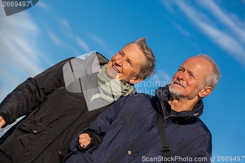 Image of happy elderly senior couple walking on beach