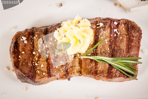 Image of Grilled beef steak topped with butter and rosemary