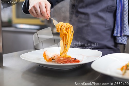 Image of Chef plating up seafood pasta