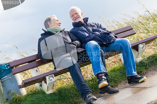 Image of happy senior couple relaxing together in the sunshine