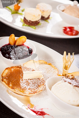 Image of tasty sweet pancakes with vanilla icecream and topping