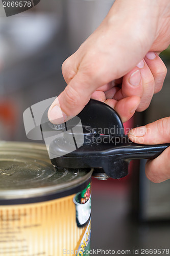 Image of Man opening a tin of canned food