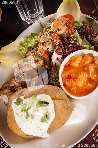 Image of Grilled prawns with endive salad and jacket potato