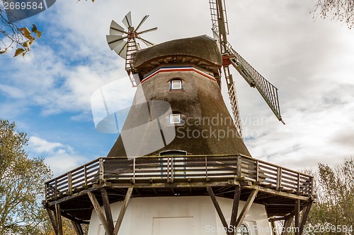 Image of Traditional wooden windmill in a lush garden