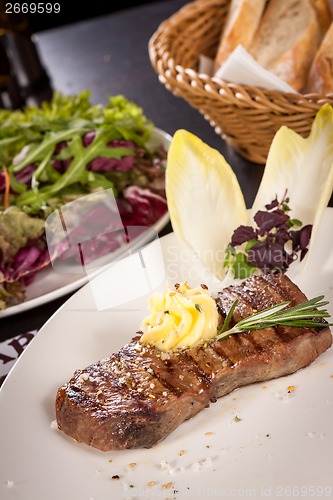 Image of Grilled beef steak topped with butter and rosemary