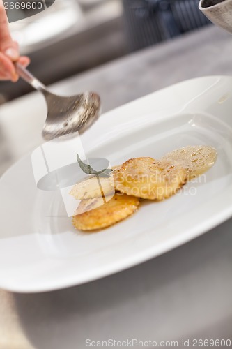 Image of Chef grating truffle mushroom onto ravioli pasta