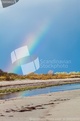 Image of Rainbow over tidal mud flats at the coast