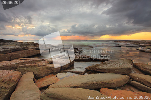 Image of Sun rays, rocks and storm clouds