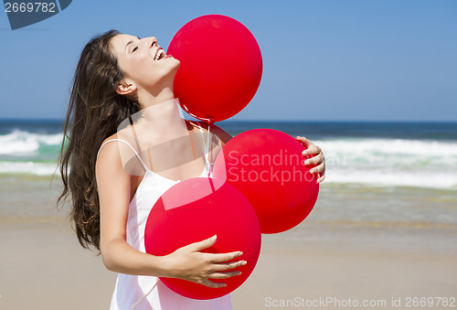 Image of Beautiful girl holding red ballons