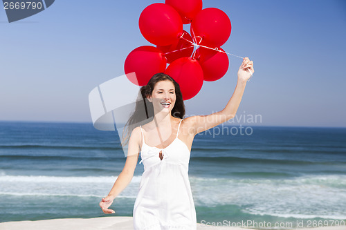 Image of Beautiful girl holding red ballons