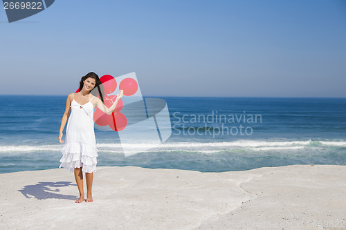 Image of Beautiful girl holding red ballons