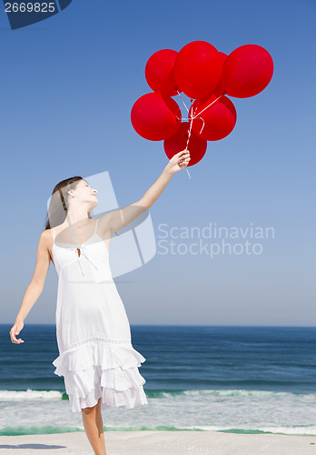 Image of Beautiful girl holding red ballons