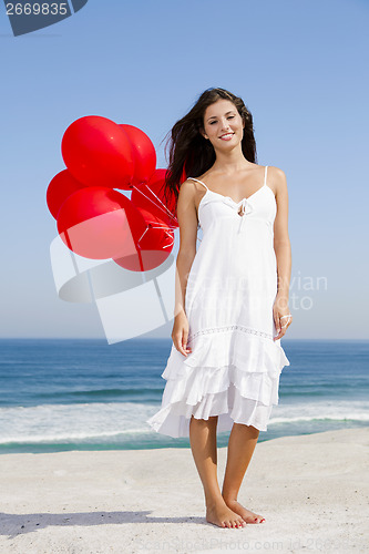 Image of Beautiful girl holding red ballons