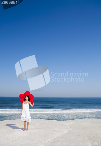 Image of Beautiful girl holding red ballons