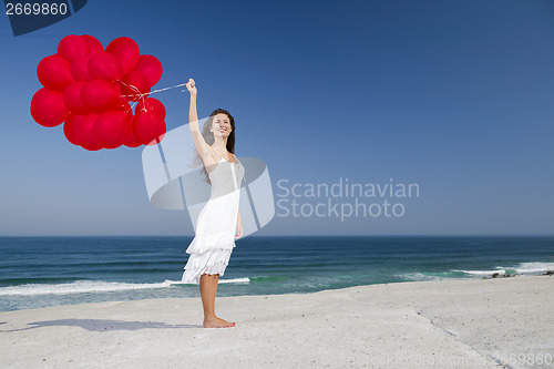 Image of Beautiful girl holding red ballons