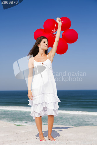 Image of Beautiful girl holding red ballons