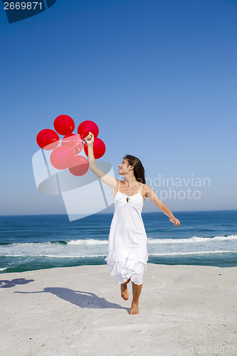 Image of Beautiful girl running with red ballons