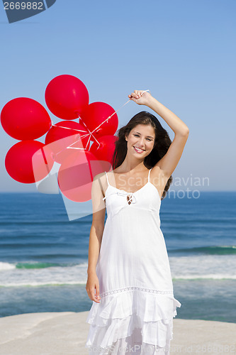 Image of Beautiful girl holding red ballons