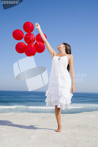 Image of Beautiful girl holding red ballons