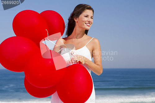 Image of Beautiful girl holding red ballons