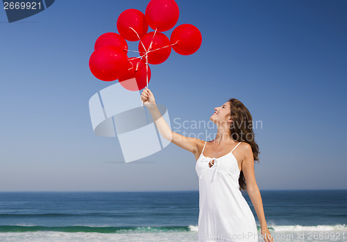 Image of Beautiful girl holding red ballons