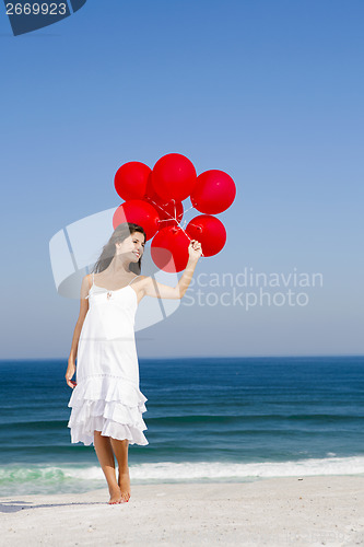 Image of Beautiful girl holding red ballons