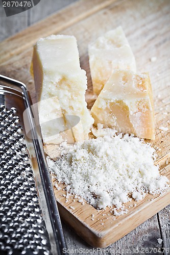 Image of grated parmesan cheese and metal grater 