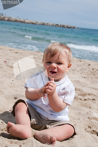 Image of Happy cute boy sitting on the beach