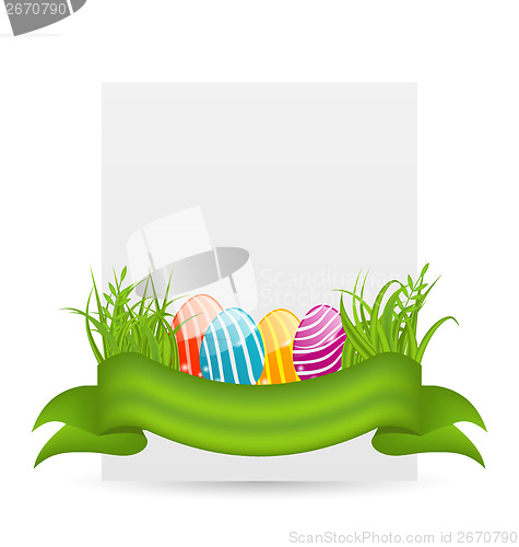 Image of Easter colorful eggs in green grass with empty paper card for yo