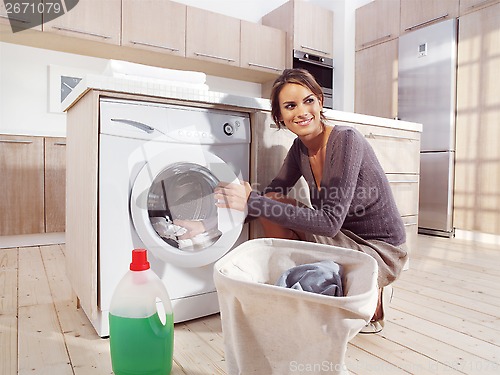 Image of woman putting cloth into washing machine