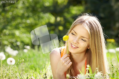 Image of Spring girl lying on the field of dandelions