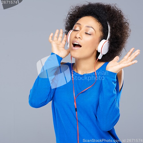 Image of Happy African American woman singing to music