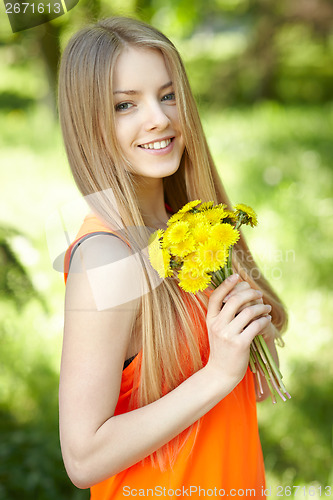 Image of Spring girl lying on the field of dandelions