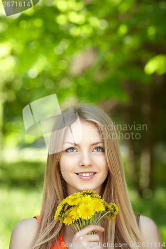 Image of Spring girl lying on the field of dandelions