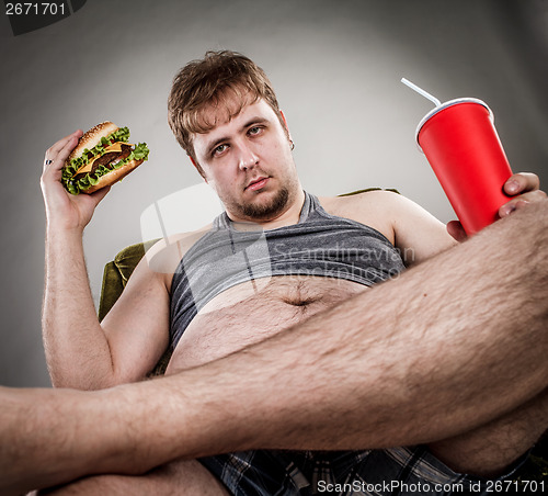 Image of Fat man eating hamburger